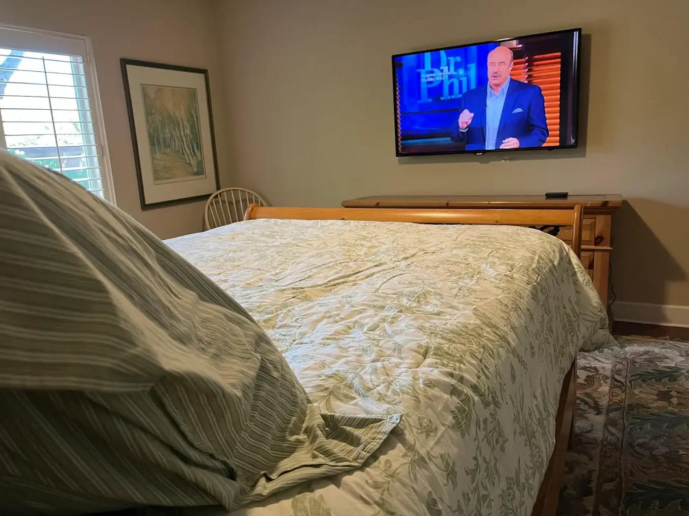 Flat screen TV wall mounted in bedroom for comfortable viewing